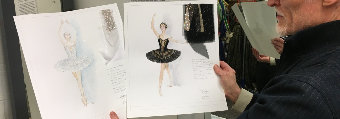 Dean Mogle holds the white and black swan design sketches for CCM's production of Swan Lake.